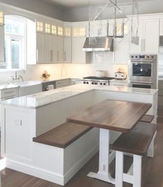 a kitchen with white cabinets and an island bench next to the stove, oven and microwave