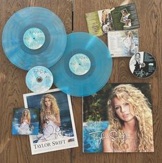 three blue records and two cds on a wooden table