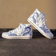 These Blue Dragon Blue Ceramic White high top canvas shoes are ideal for being unique and standing out from the rest of the crowd. To be Gnarly, you need to be different and feel different. These shoes will help you express yourself through the intricate art and gnarly design it displays. This unique shoe is hand drawn/designed in the USA and built with fantastic quality. CONSTRUCTION: Our shoes are very well constructed with quality stitching and a solid base. They are comfortable and durable and suitable for most occasions. HANDCRAFTED DESIGN: Wearing these shoes is making a statement. Our shoes have bold and gnarly designs that fit anyone who want to separate themselves from the rest. The designs are inspired by art and beauty from around the world. Exclusively designed in the USA. __FE Shoes With Drawings On Them, Nike Shoe Painting Ideas, White Sneakers Painting Ideas, White Converse Custom Ideas, Converse Painting Ideas High Tops, Custom Shoe Design Ideas, Dragon Converse, Shoe Painting Ideas Converse, Painted Converse High Tops