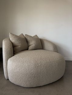 a large round couch sitting in front of a white wall