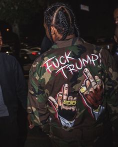 a man in camo jacket walking down the street with his hand painted on it