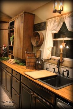 an old fashioned kitchen with wooden cabinets and counter tops, including a large black sink