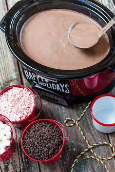 hot chocolate and marshmallows are in the crock pot with candy canes