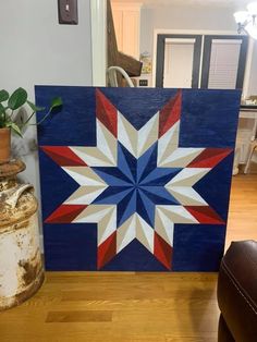 a blue and red star painted on a wood block in the middle of a living room
