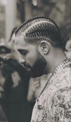 a black and white photo of a man with dreadlocks in his hair looking down