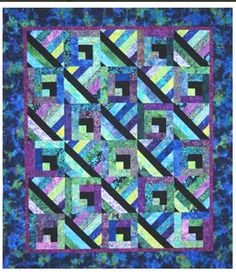 a blue and green quilt with black strips on the center, in front of a dark background