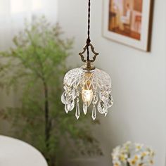 a chandelier hanging from a ceiling in a room with flowers on the table