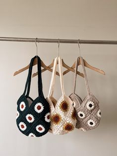 three crocheted purses hanging on a clothes line