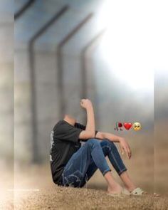 a boy sitting on the ground with his arms up and two hearts flying in the air