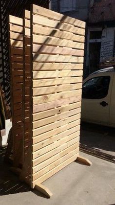 a wooden structure sitting next to a white car