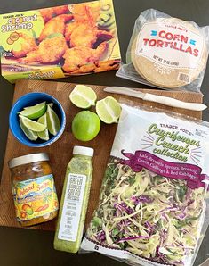 ingredients to make chicken salad laid out on a cutting board next to an open bag of tortillas