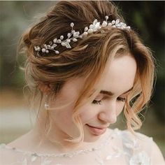 a woman wearing a tiara with flowers on it's head and hair comb