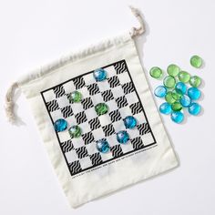 a bag filled with lots of green and blue candies on top of a white table