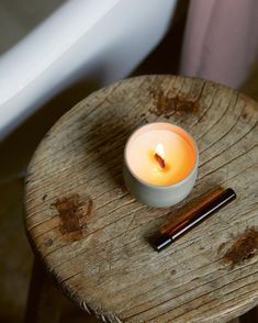 a lit candle sitting on top of a wooden table