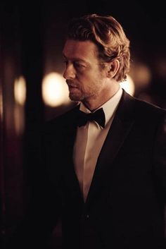 a man in a tuxedo looks off into the distance