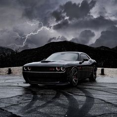 a black car parked in front of a storm