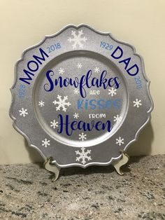 a snowflakes plate with the words mom, dad and kisses from heaven on it