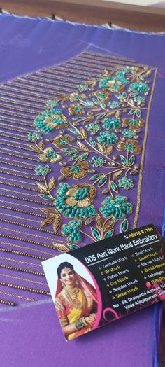 a purple table cloth with an embroidered design on it and a business card attached to it
