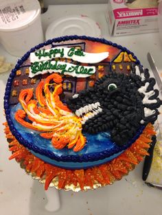 a birthday cake decorated to look like a monster with orange and black frosting on it