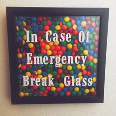 there is a sign that says in case of emergency break glass with lots of gumballs