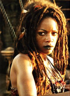 a woman with dreadlocks on her face and chest is staring at the camera