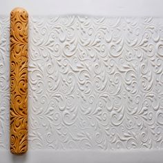 a piece of carved wood sitting on top of a white wall