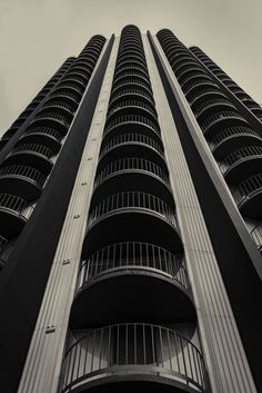 an upward view of a tall building with balconies on the top and bottom