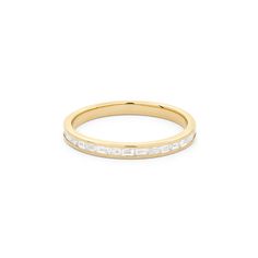 a yellow gold wedding band with baguettes on the side and white diamonds in the middle