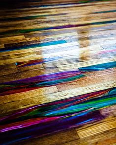 the floor is covered with multicolored strips of yarn on top of wooden floors