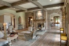 a living room filled with furniture and a fire place in the middle of an open floor plan