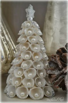 a white christmas tree made out of rolled up toilet paper rolls and some pine cones