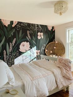 a bedroom with floral wallpaper and white bedding