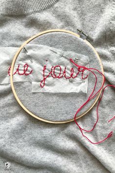 an embroidery project with the word be yourself written on it in red thread and surrounded by scissors