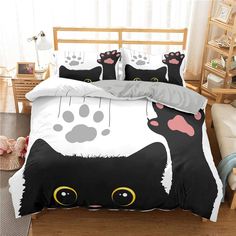 a black and white cat with paw prints on it's face is shown in this bedding set