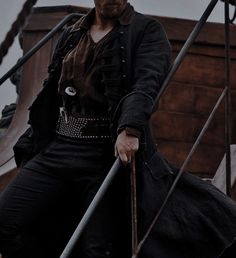 a man dressed in pirate garb on the deck of a ship