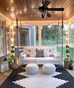 a white couch sitting on top of a black and white rug under a ceiling fan