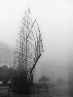 an old photo of a sailboat in the fog