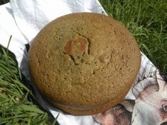 a brown cake sitting on top of a napkin in the grass