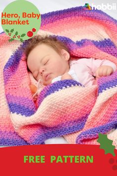 a baby wrapped in a blanket sleeping on top of a red and pink blanket with holly berries