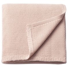 a pink blanket folded on top of a bed