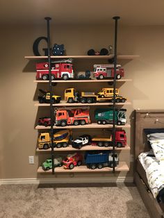 there are many toy trucks on the shelves in this child's playroom area