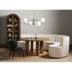 a living room filled with furniture next to a book shelf and lamp hanging from the ceiling