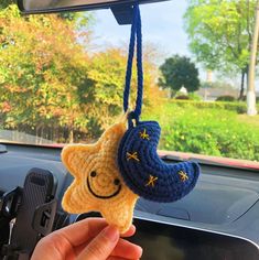 someone is holding up a crocheted star ornament in the back of a car