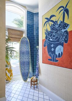 there is a painting on the wall and a surfboard in the room next to it