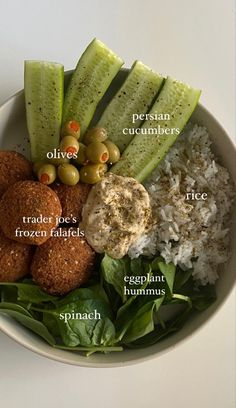 a white bowl filled with rice, cucumbers and other foods on top of it