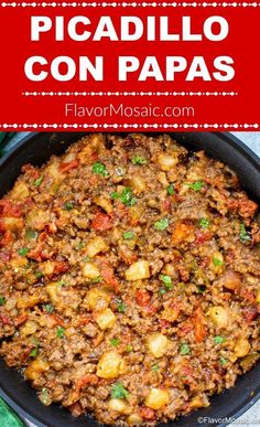 a skillet with meat and potatoes in it on top of a green table cloth