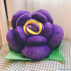 a purple flower sitting on top of a green pillow