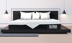 a black and white bed with four pillows