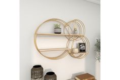 a shelf with two vases on it next to a potted plant and some books