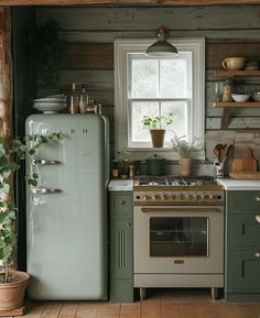 a kitchen with green cabinets and an old fashioned stove in the center, surrounded by potted plants